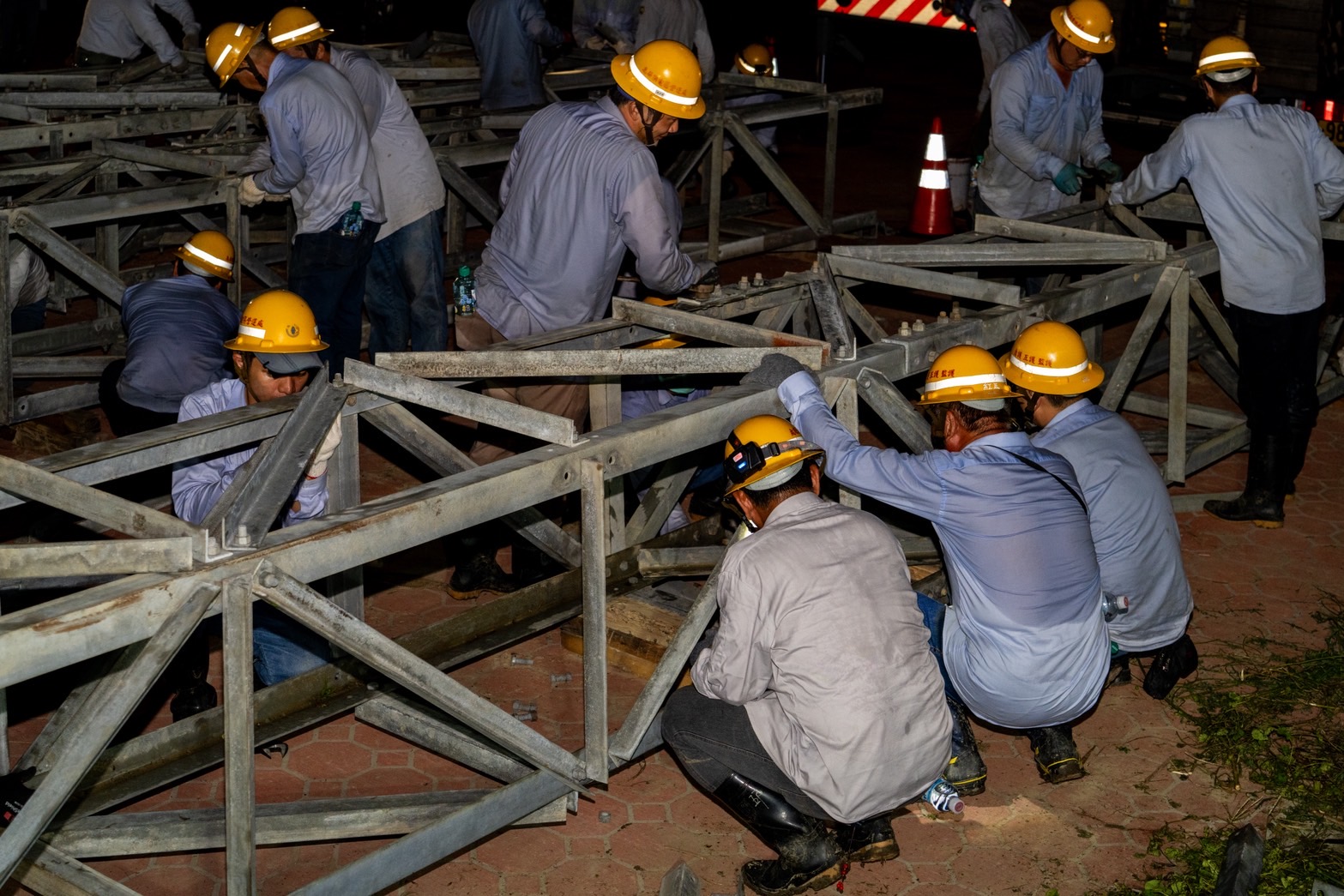 嘉義布袋新塭變電所3座6.9萬伏特高壓電塔更遭強風吹倒。圖為台電同仁加速組裝新鐵塔。